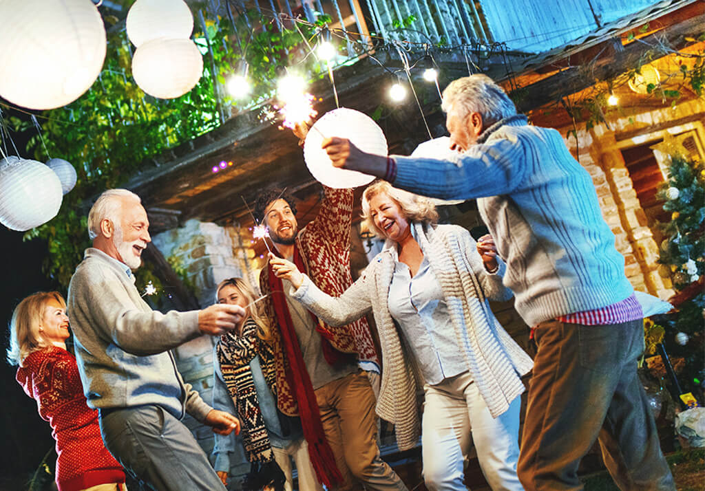 Een groep van 6 mensen met verschillende leeftijden aan het dansen, lachen en genieten van het leven.