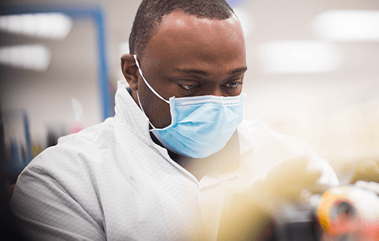 Man met masker aan het werk in een laboratorium