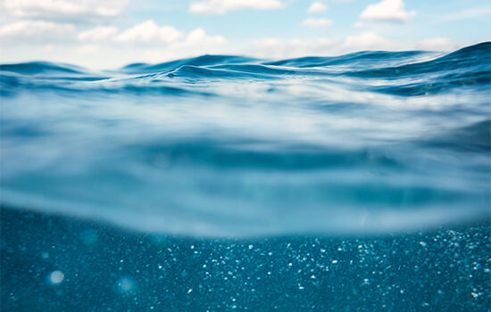 Foto van oceaangolven met een blauwe lucht, gemaakt vanuit het water